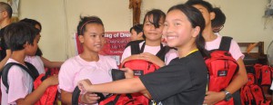 Cassie gives her bags of dreams filled with school supplies to Lucena students