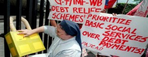 A Roman Catholic nun puts a symbolic padlock on the main gate of the Philippine Central Bank during a rally against foreign debt in Manila in this 1999 file photo. 